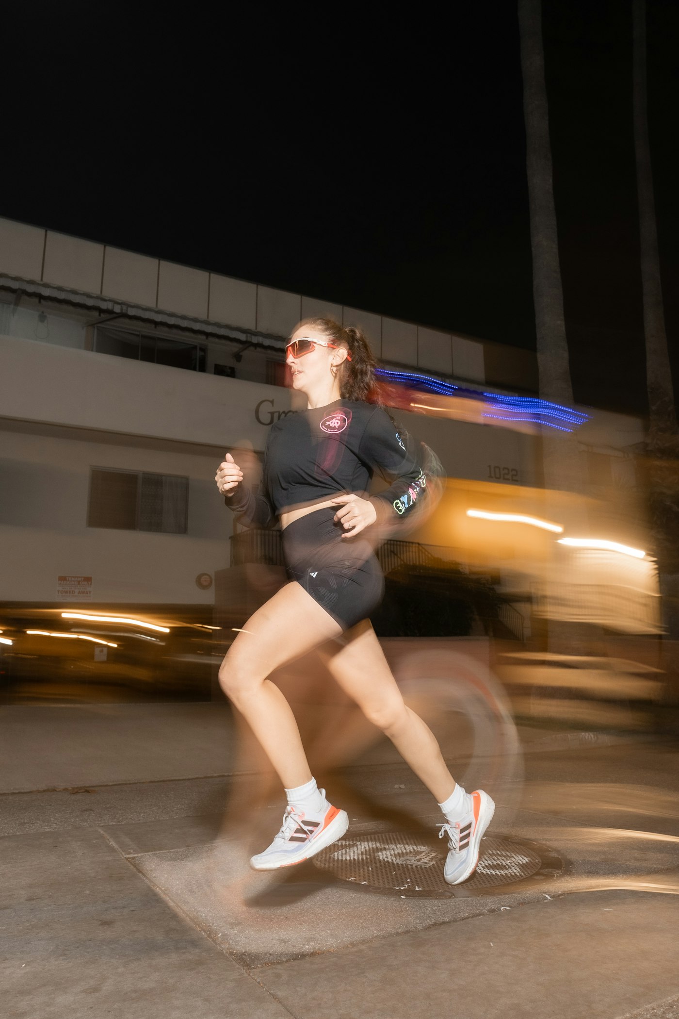 A person running along a city street at night